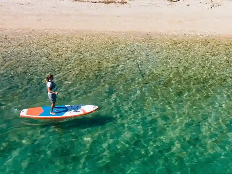 Paddleboarder on clear turquoise water off Nikiana